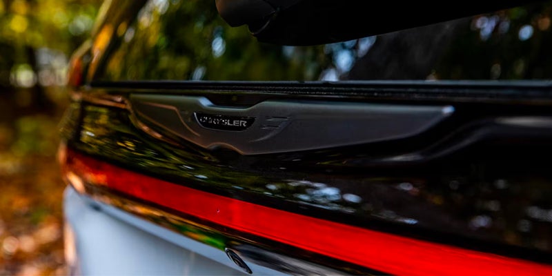 Family with white Chrysler Pacifica near beach at sunset
